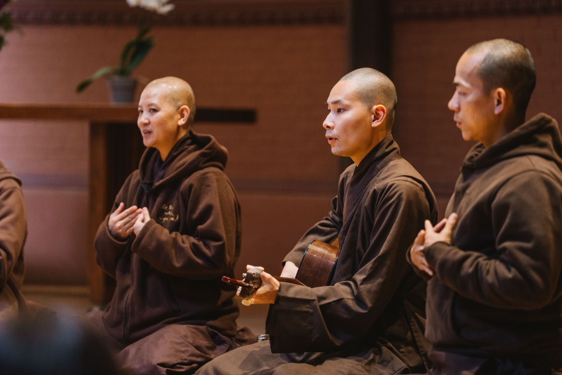 Monks singing and playing guitar