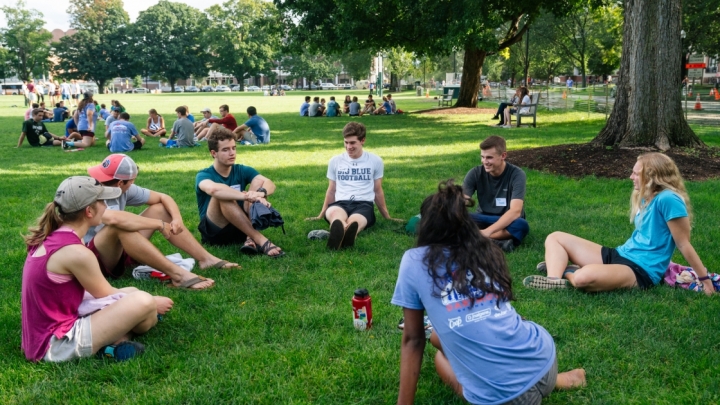 students sitting in circle on grass