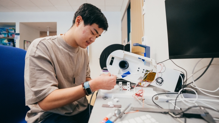 A student in a lab working with wires