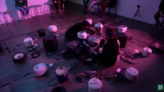 Rice cookers set up around the floor with purple lighting