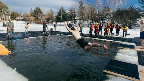 Student bellyflopping into a frozen Occom Pond