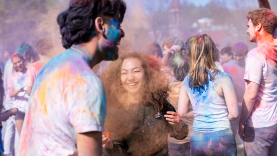 Students throw powdered color on each other during Holi