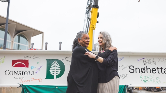 Laurel Richie '81 and Mary Lou Aleskie embrace after signing the steel beam