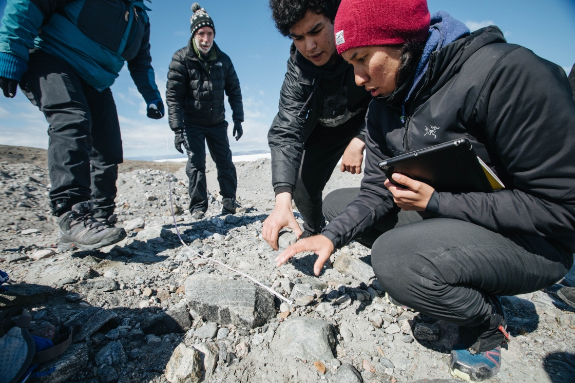 Miila Lennert, a Greenlandic teacher with JSEP helps students collect and analyze rocks as part of a geomorphology project.