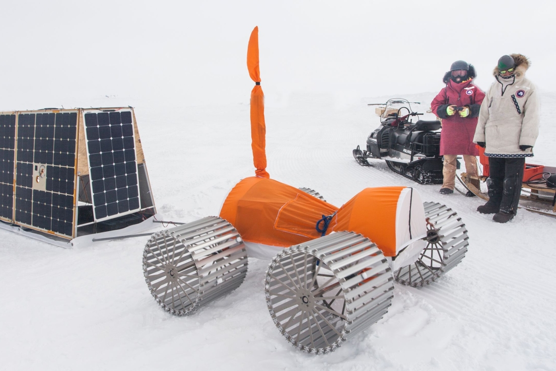 “FrostyBoy,” an orange and silver driverless, solar-powered machine, helps in gathering data from below the surface of the ice sheet.