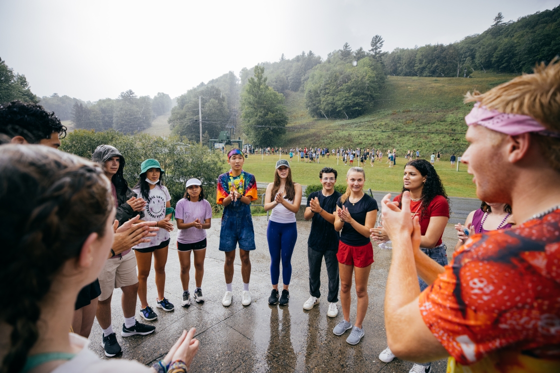 Students pose in a circle in the rain during first-year trips