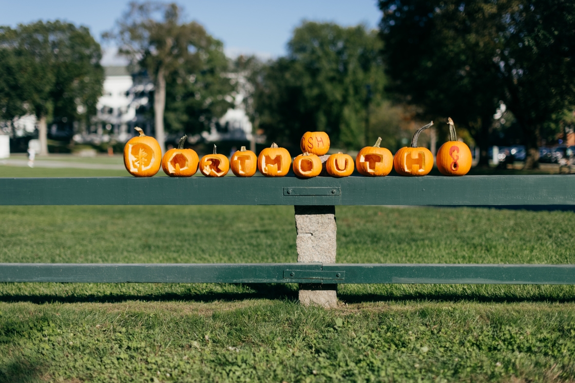 Pumpkins on a fence that are carved &quot;Dartmouth&quot;