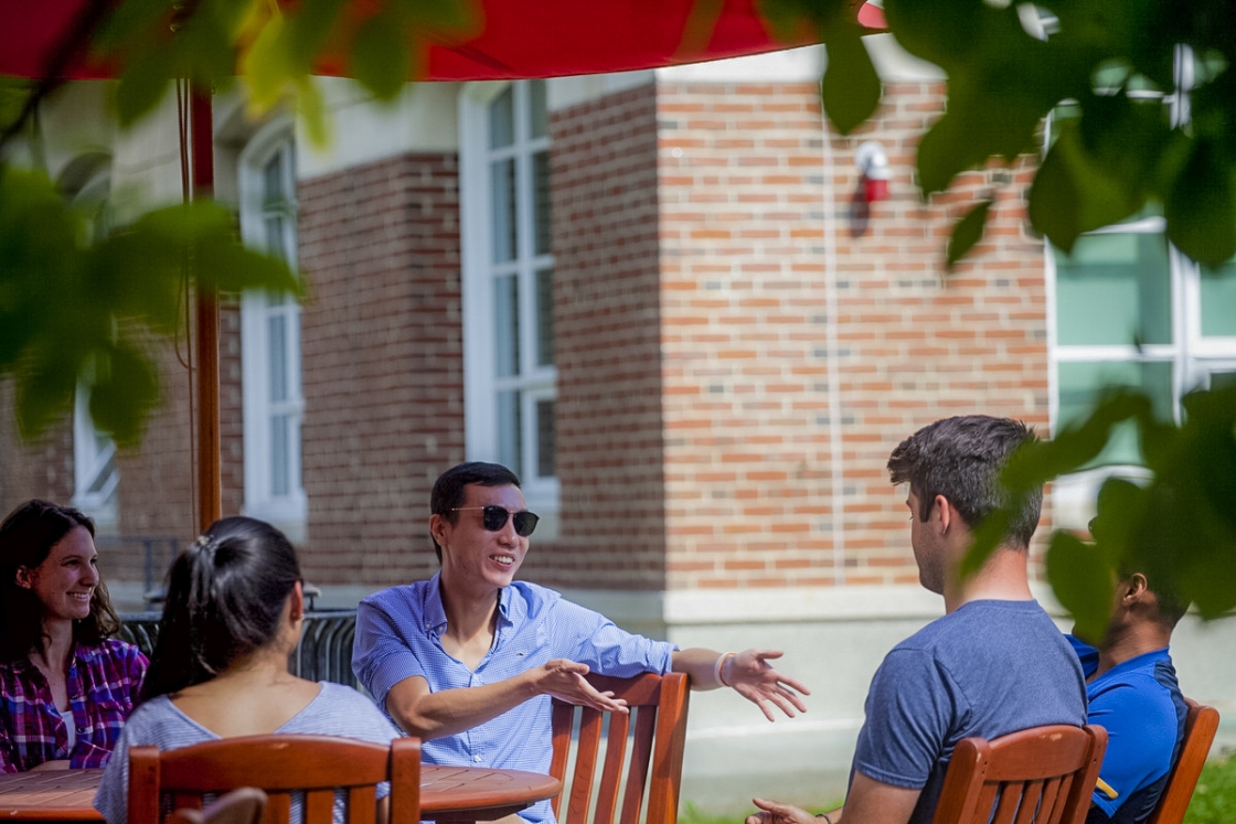 People having a conversation outside of a brick building