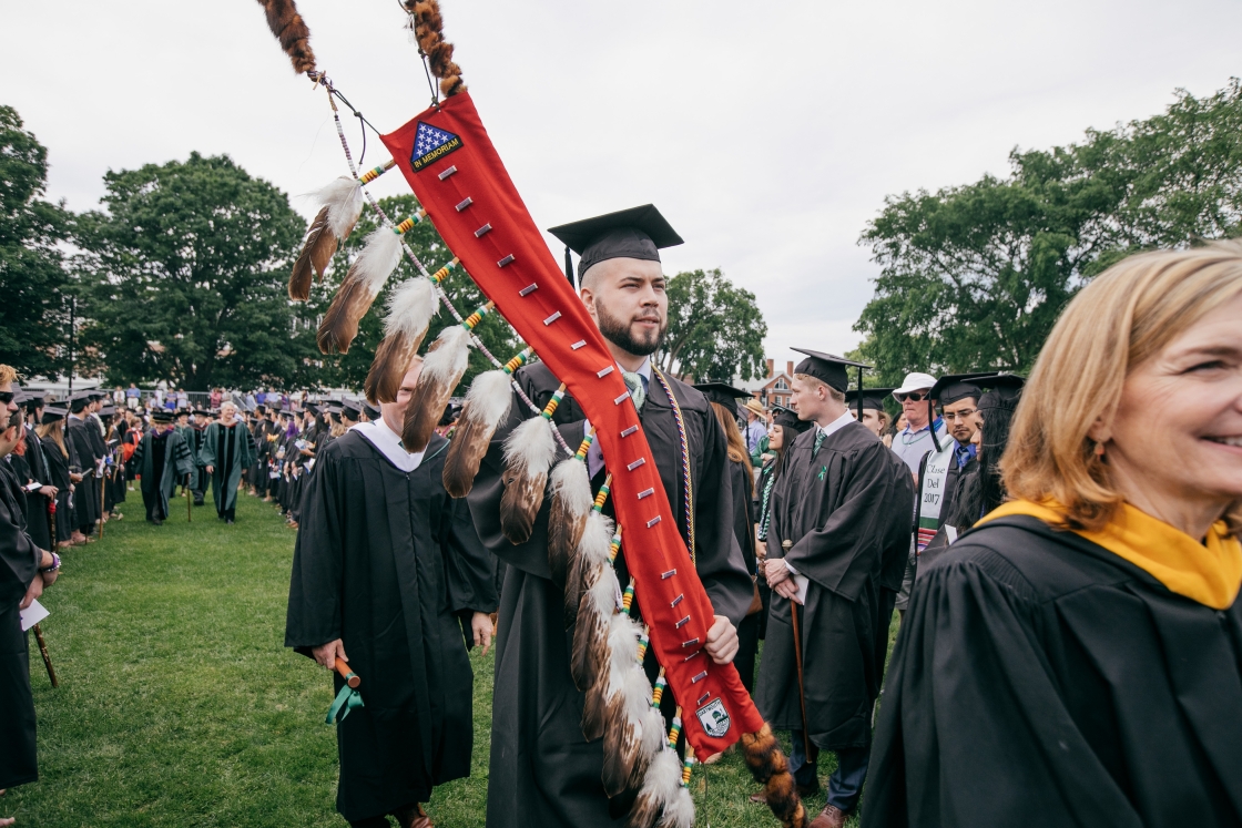 Person carrying Native veterans flag at commencement