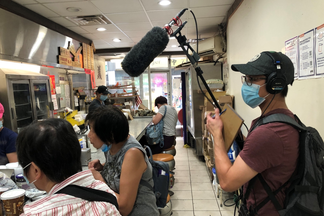 Daniel Lam '22 uses a boom mic for interviewing at a café