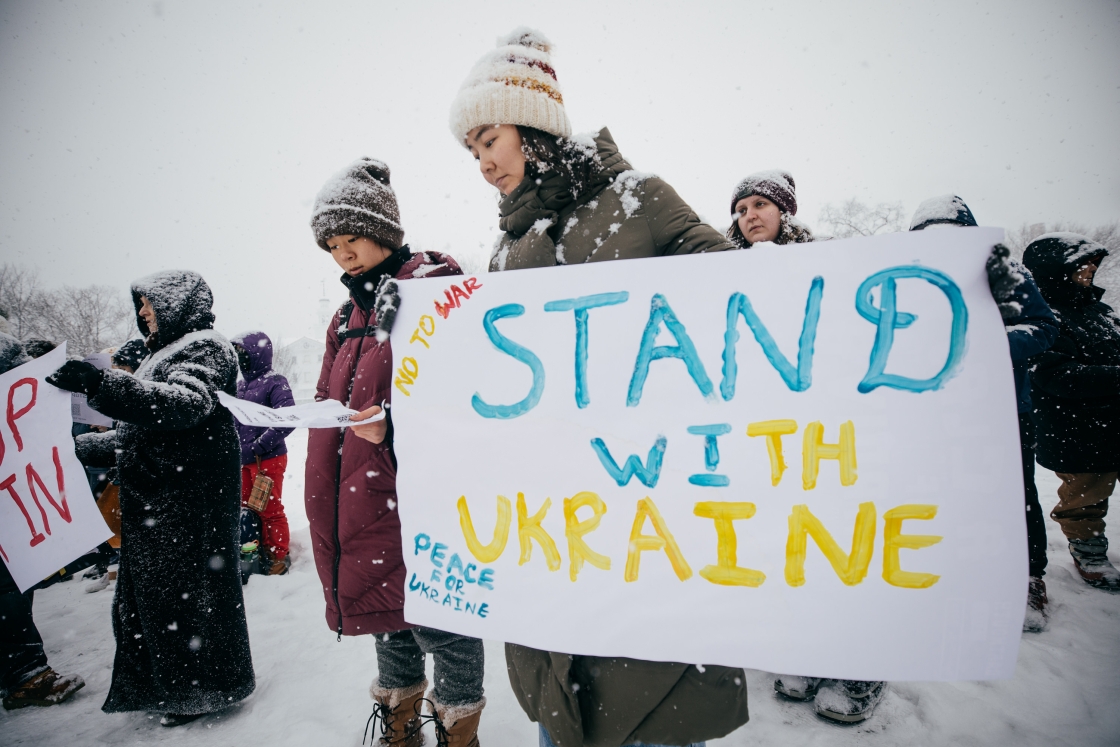 Woman with poster that reads &quot;Stand with Ukraine&quot;
