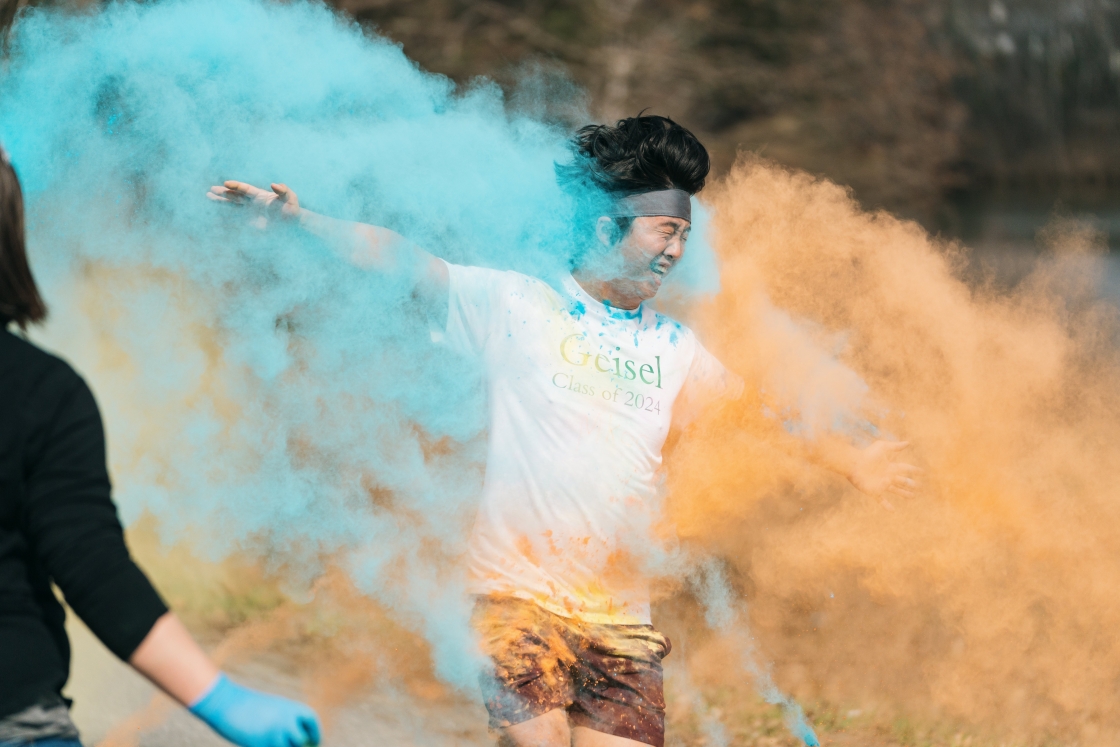 Man running and getting covered in color powder