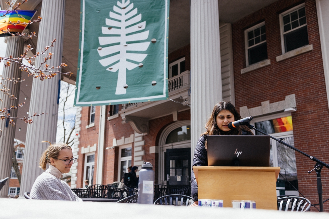 A student speaking at a podium outside of Collis