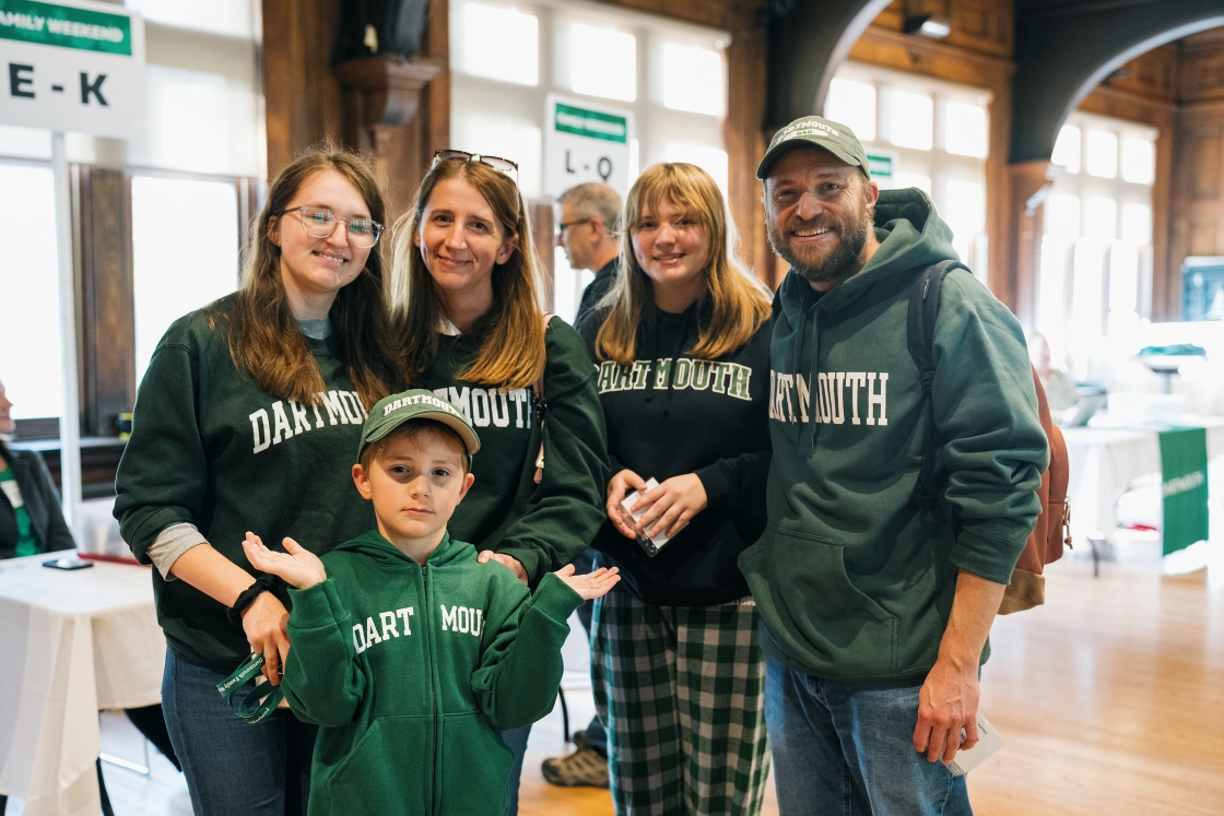 A family poses for a photo wearing Dartmouth green
