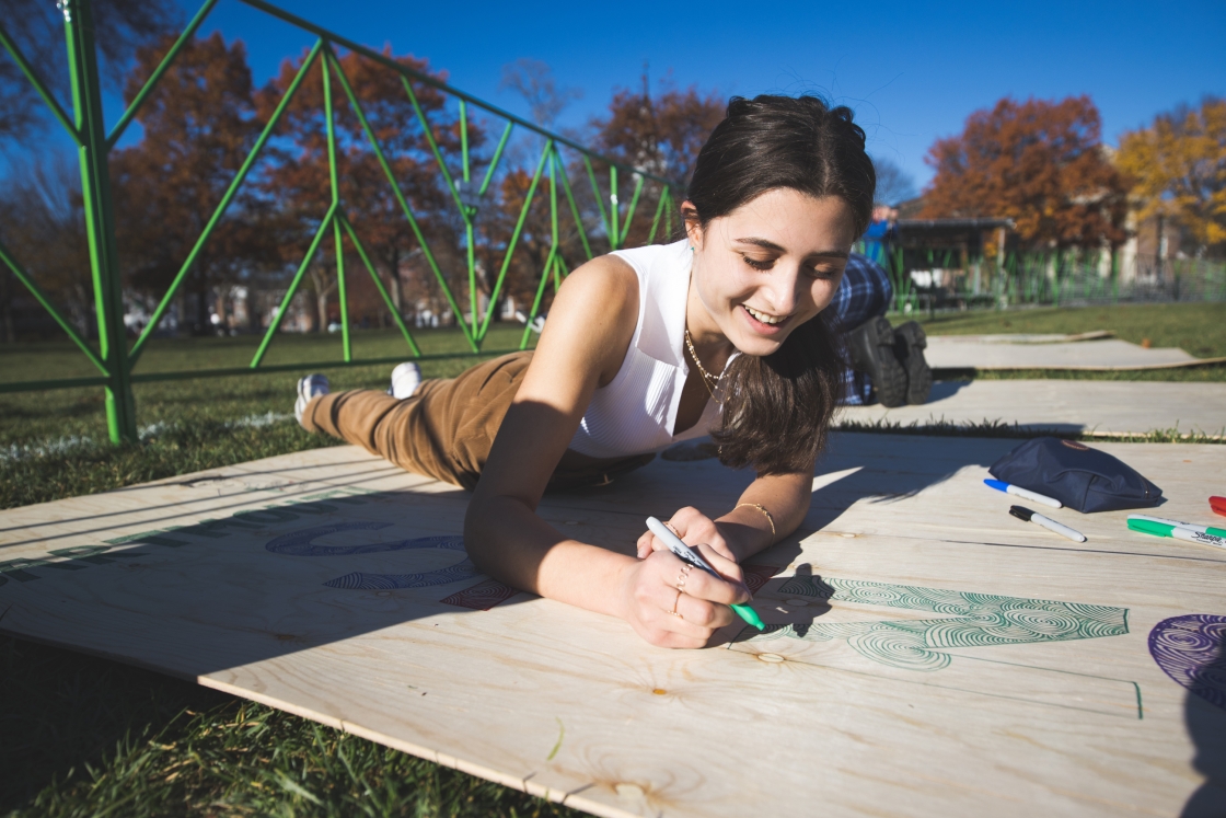 Yasmine Abouali '26 decorates a board that will be part of the bonfire structure.