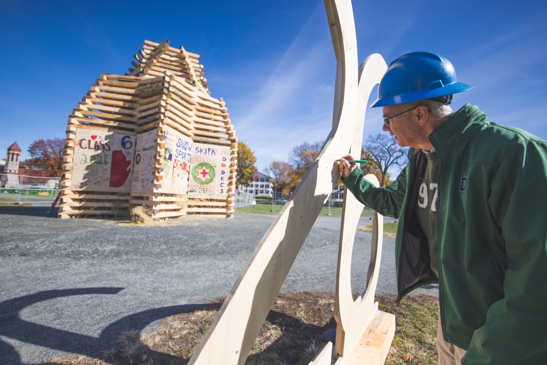 President Hanlon '77 signs the 26 that will go on top of the bonfire.