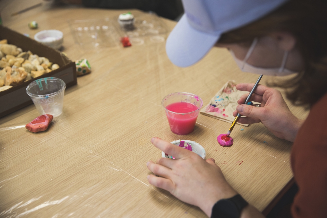 Damien Jeffers '23 paints a rock.