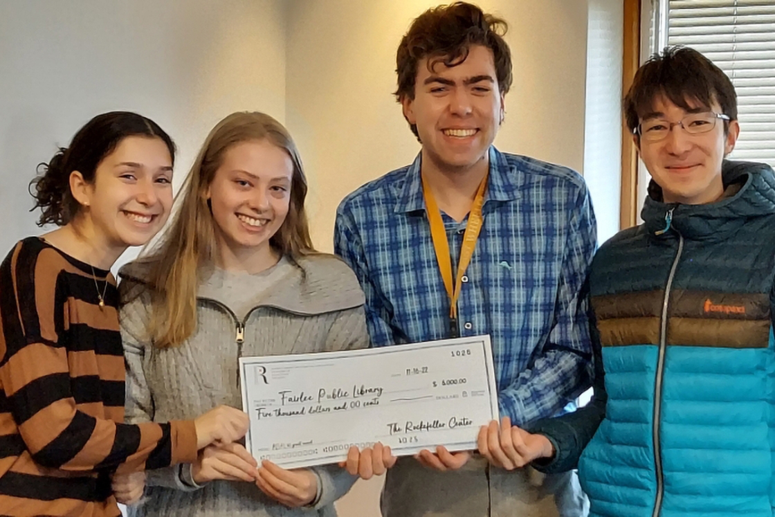 4 students holding a check