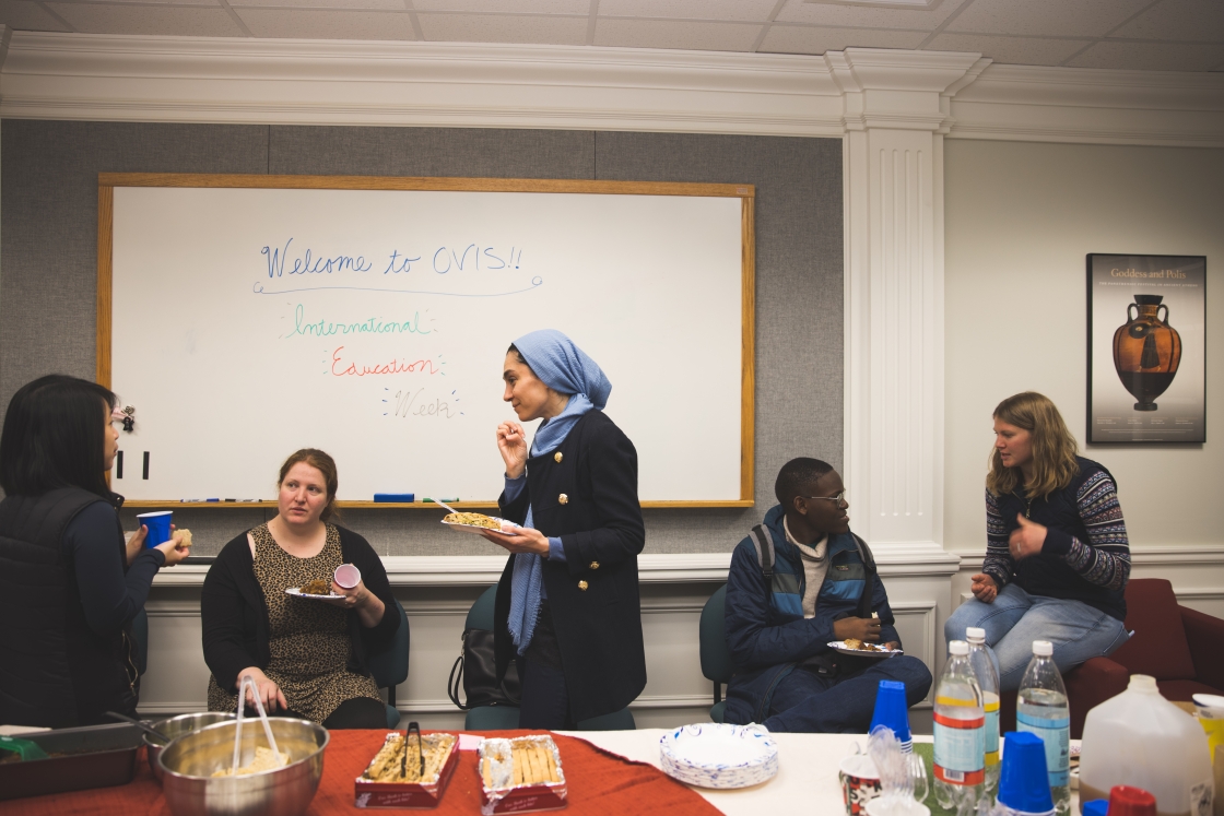 People eating and talking in the Office of Visa and Immigration Services