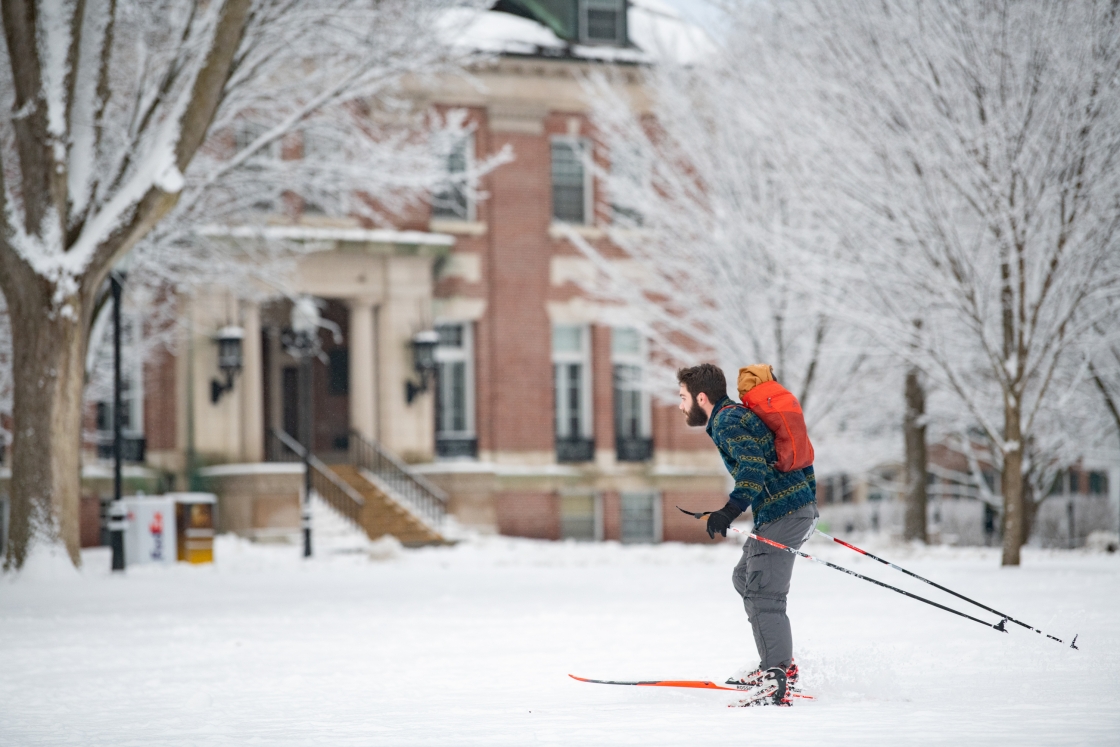 A student nordic skiing across the Green