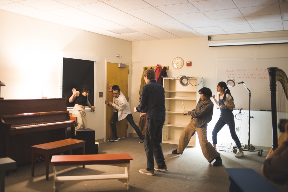 Students circled up acting in the corner of a room