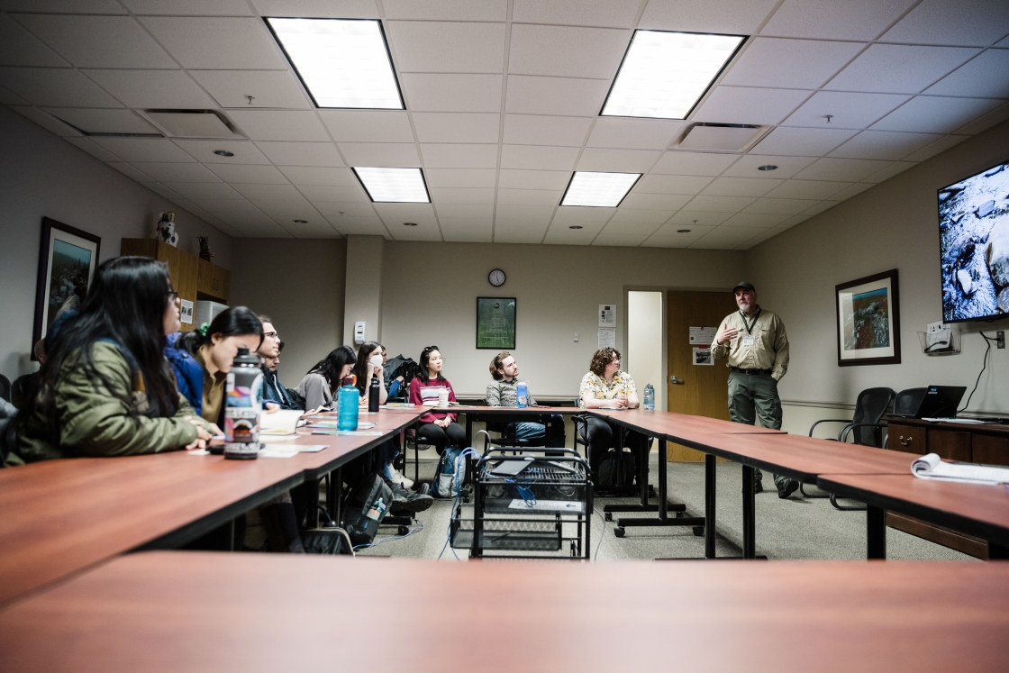 Students sit around a table in a classroom