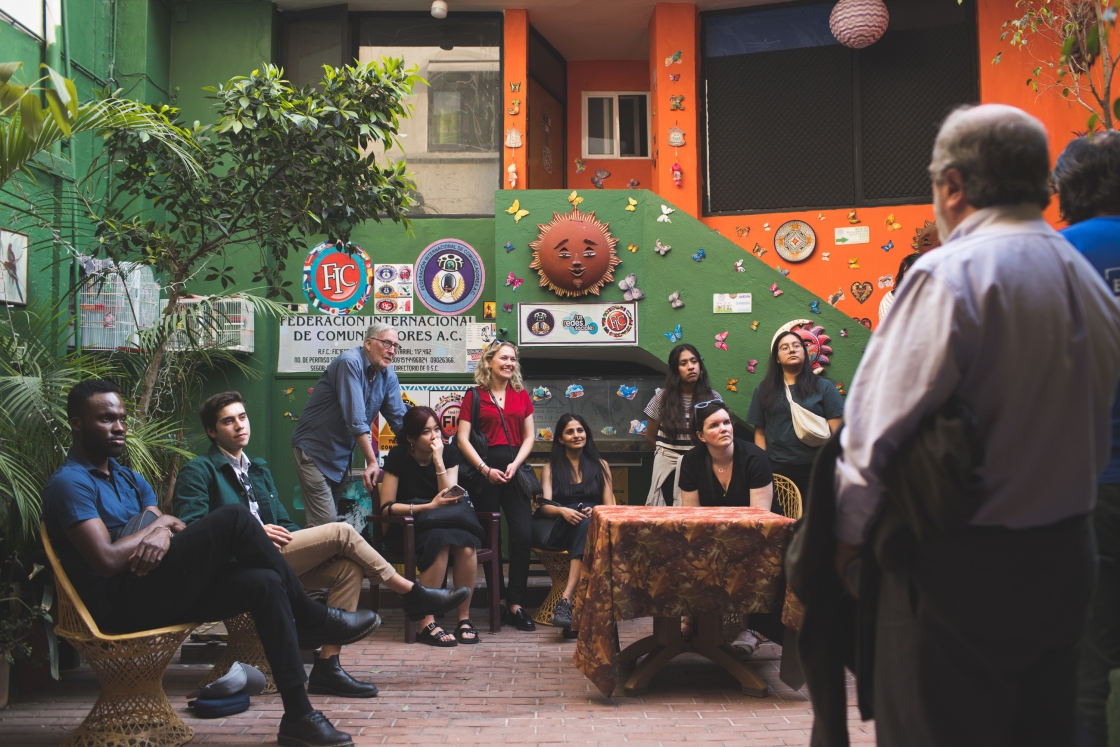 Students and others gathered in a green and orange room