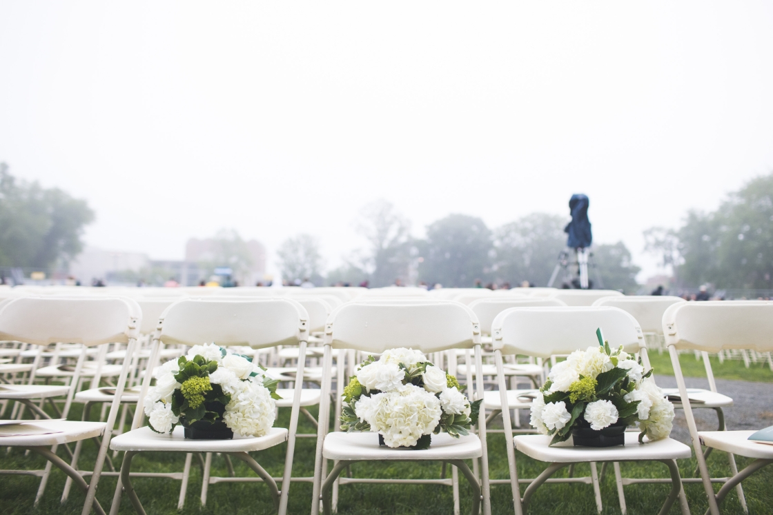 Flowers resting on chairs at Commencement, symbolizing deceased class members