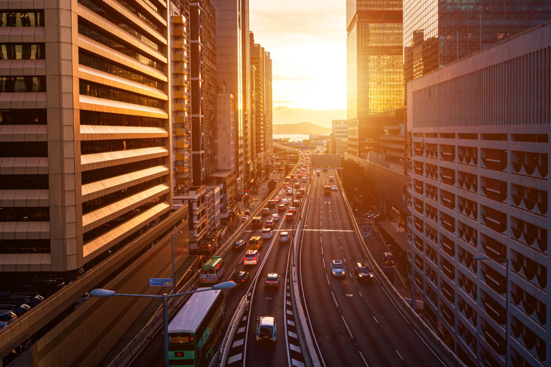 Cars traveling between city high rise buildings