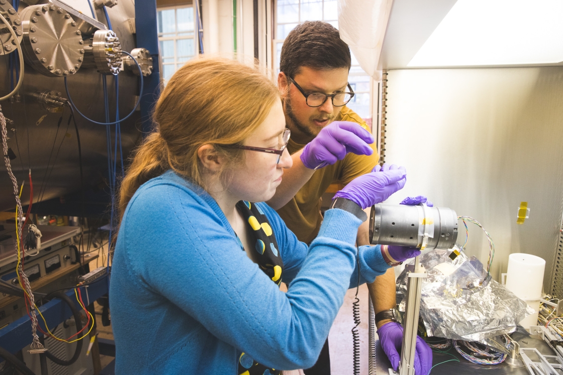 Guarini PhD students Magdalina Moses, left, and Jules Van Irsel work on a model instrument at Dartmouth.