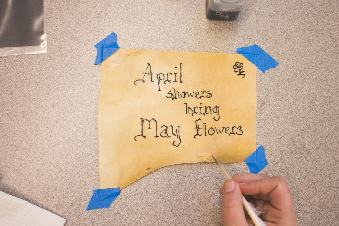 Quill and ink writing of &quot;April showers bring May flowers&quot;