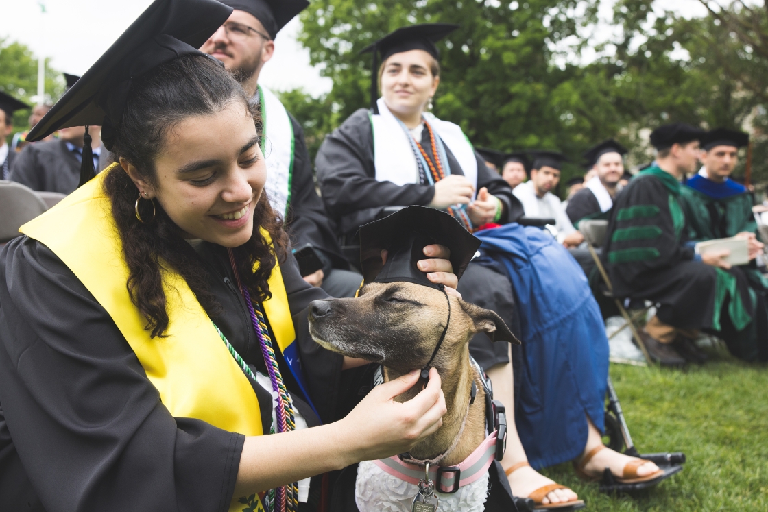 A Dartmouth graduate pets their dog