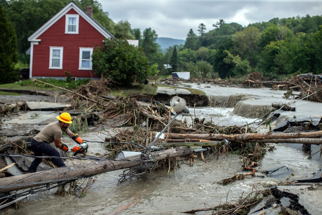 Worker clears tree amid flooding