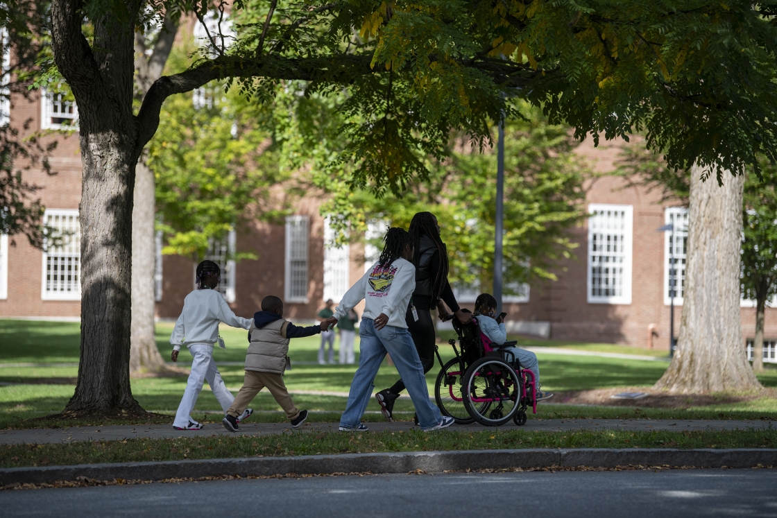 A Dartmouth family walks along the sidewalk on campus