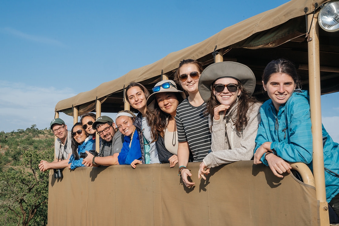 Students pose for a photo in the back of the safari vehicle.