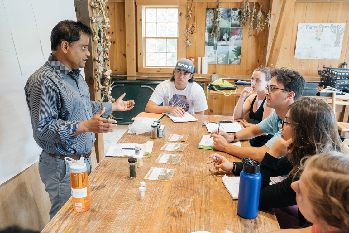 A professor teaches an environmental studies class at the organic farm