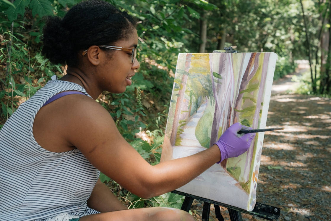 Melissa Biggs '18 paints for her Painting 01 class on the path to the BEMA