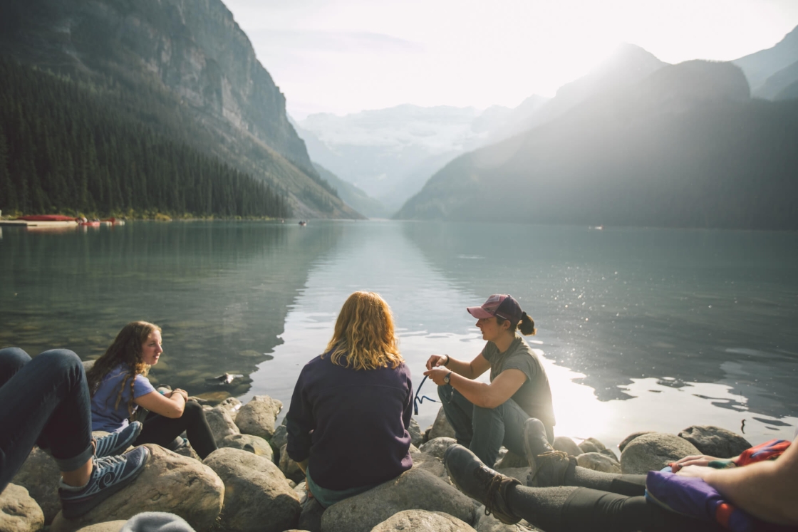 Students sit on the bank of Lake Louise in Banff National Park.