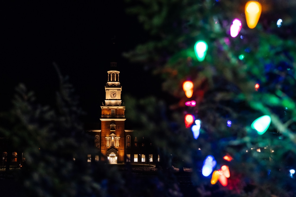 Baker Tower is lit up in the background with a Christmas tree in the foreground