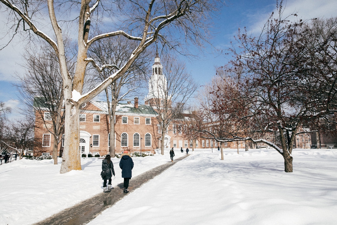 Students walk near Baker Library on a snowy day
