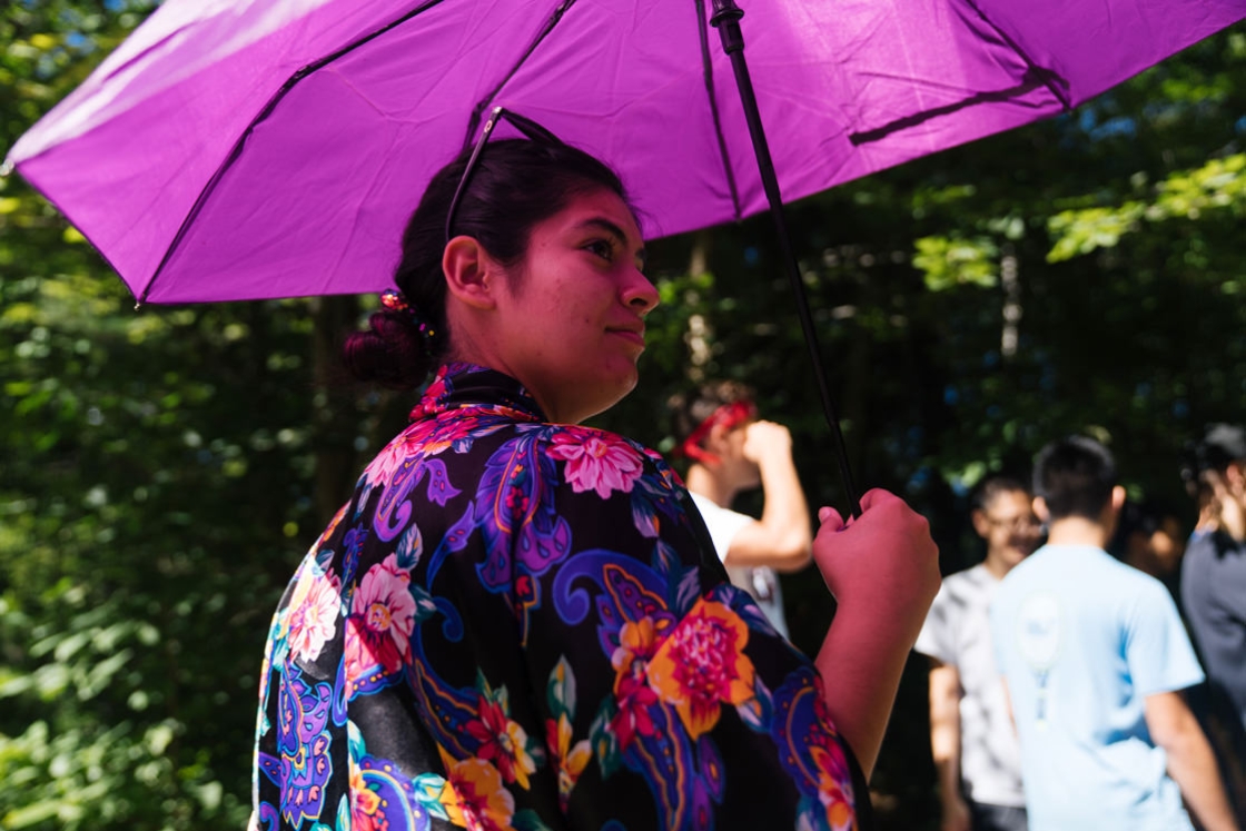 Yadira Torres '19 explains the plight of the mermaid princess to trippies under the shade of a purple parasol.