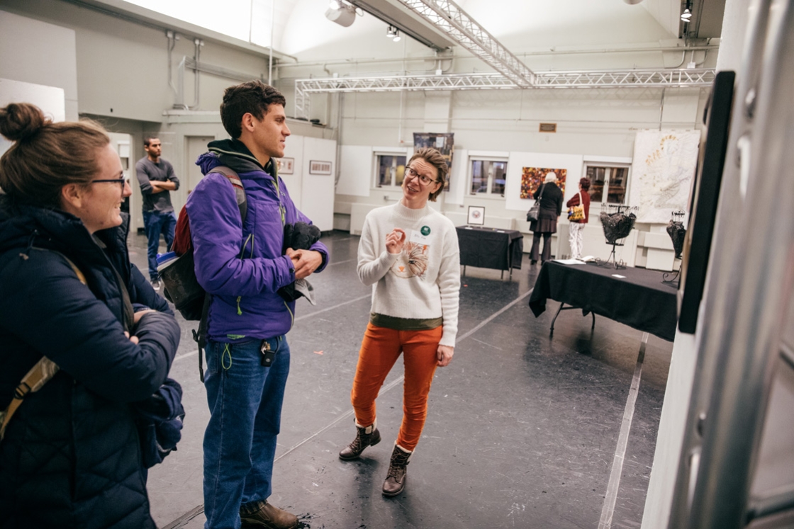 Kelly Finn, a Neukom postdoctoral fellow, talks about her watercolor during ArtWorks, the employee arts festival that took place Friday in the Hop Garage and Courtyard Cafe. (Photo by Robert Gill)