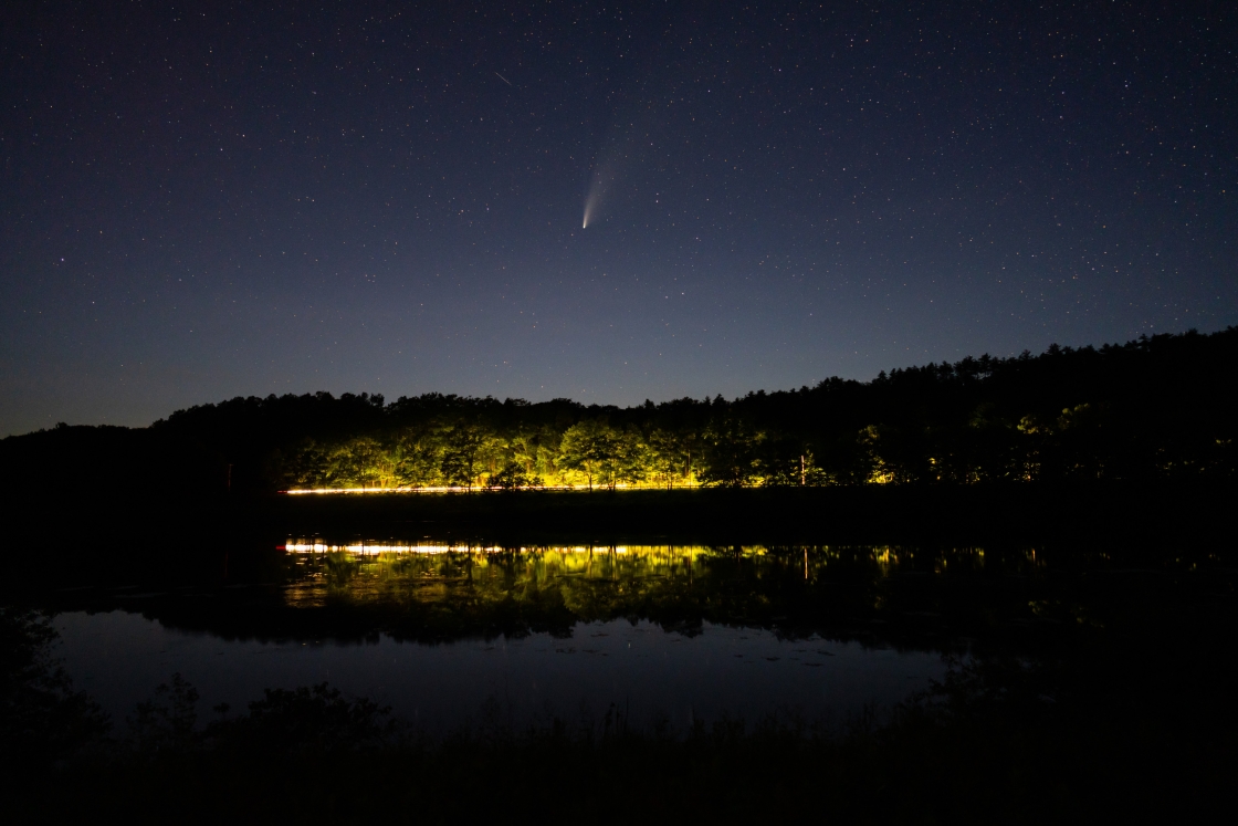 Comet over Connecticut river and lights of passing car