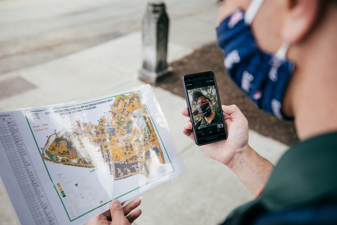 Student Life Staff member Joseph Castelot looks at a campus map as he helps facilitate the orienteering exercise.