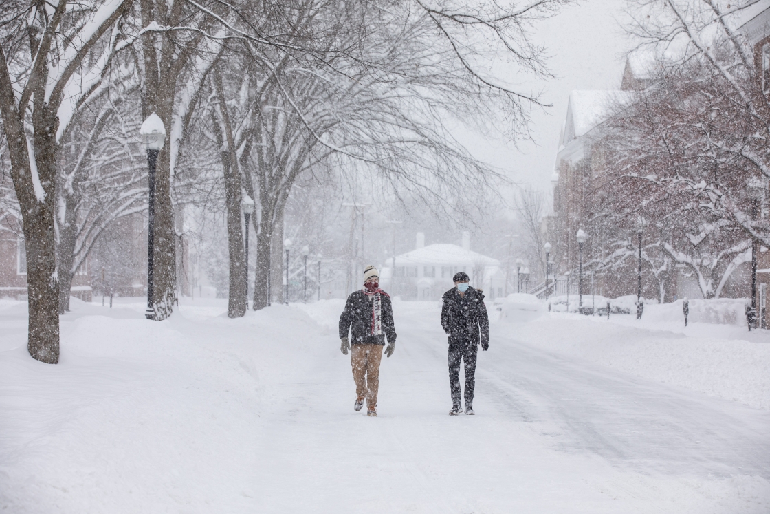 Two people walking on a snow-covered road in Hanover