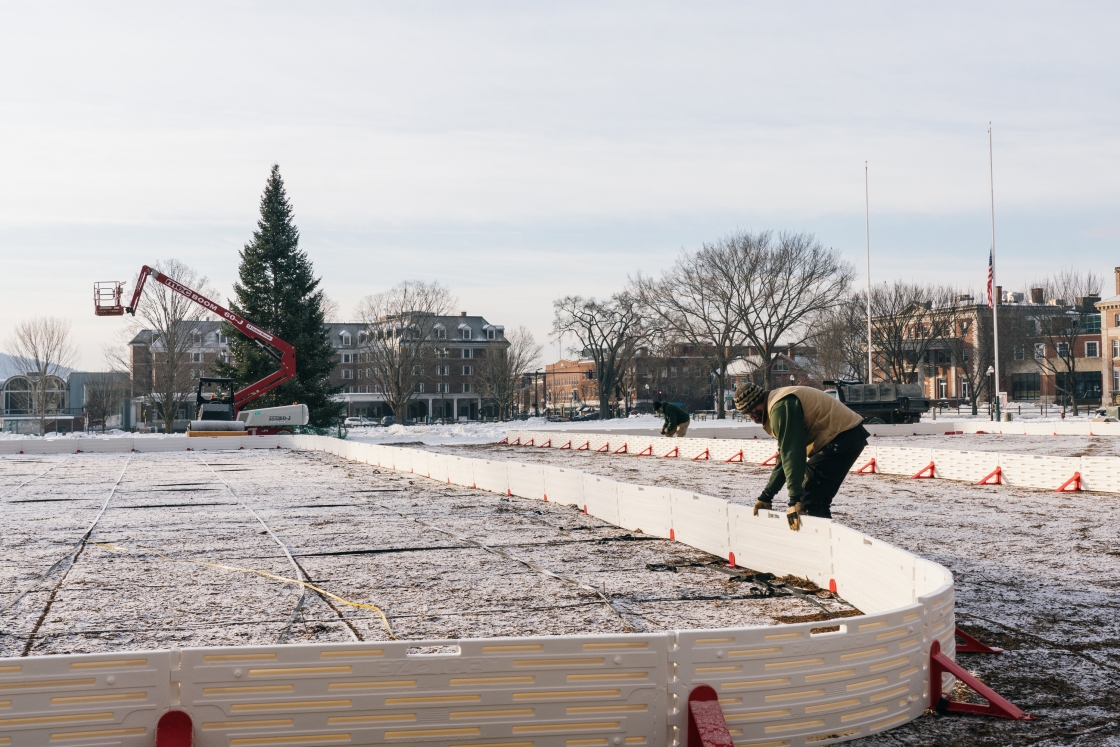 A college employee assembling rink barriers