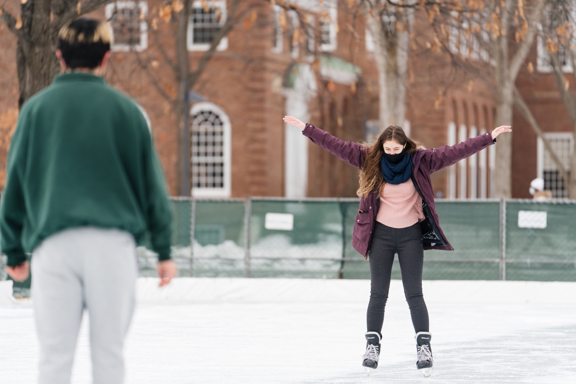 Students skating with her arms out wide.