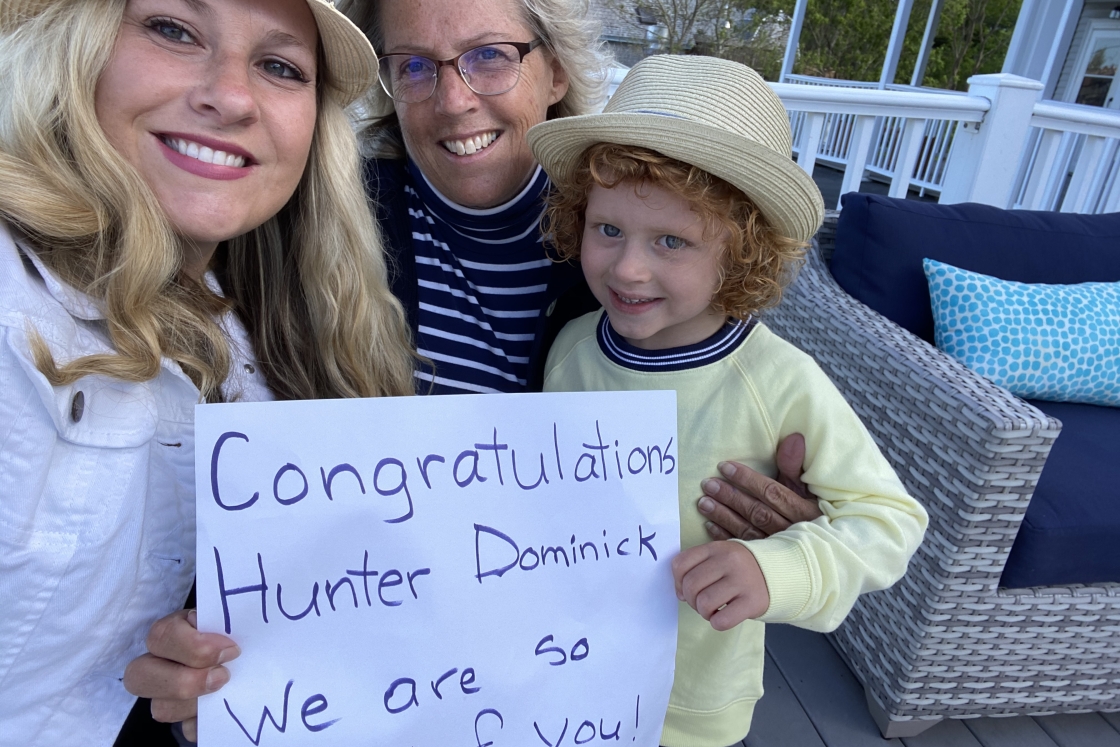Family and friends of Hunter Dominick hold congratulations signs