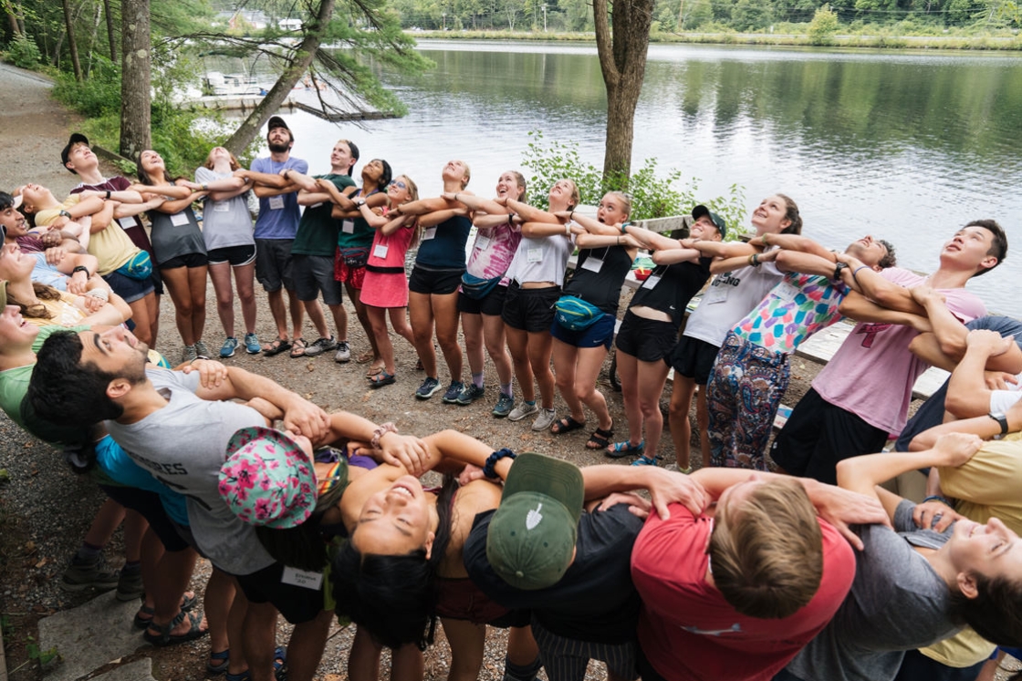 Vox Croo and first-year trip leaders link arms to support each other in a circle