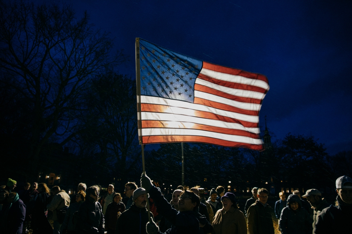 A community member waves the American flag on the Green during the Veterans Day gathering.